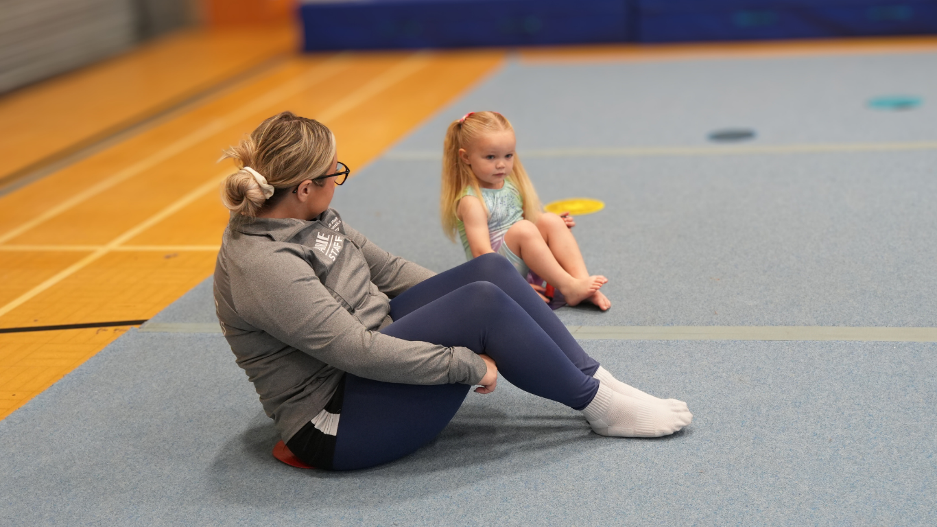 a north east gymnastics club coach with a preschool gymnasts using batons for gymnastics 