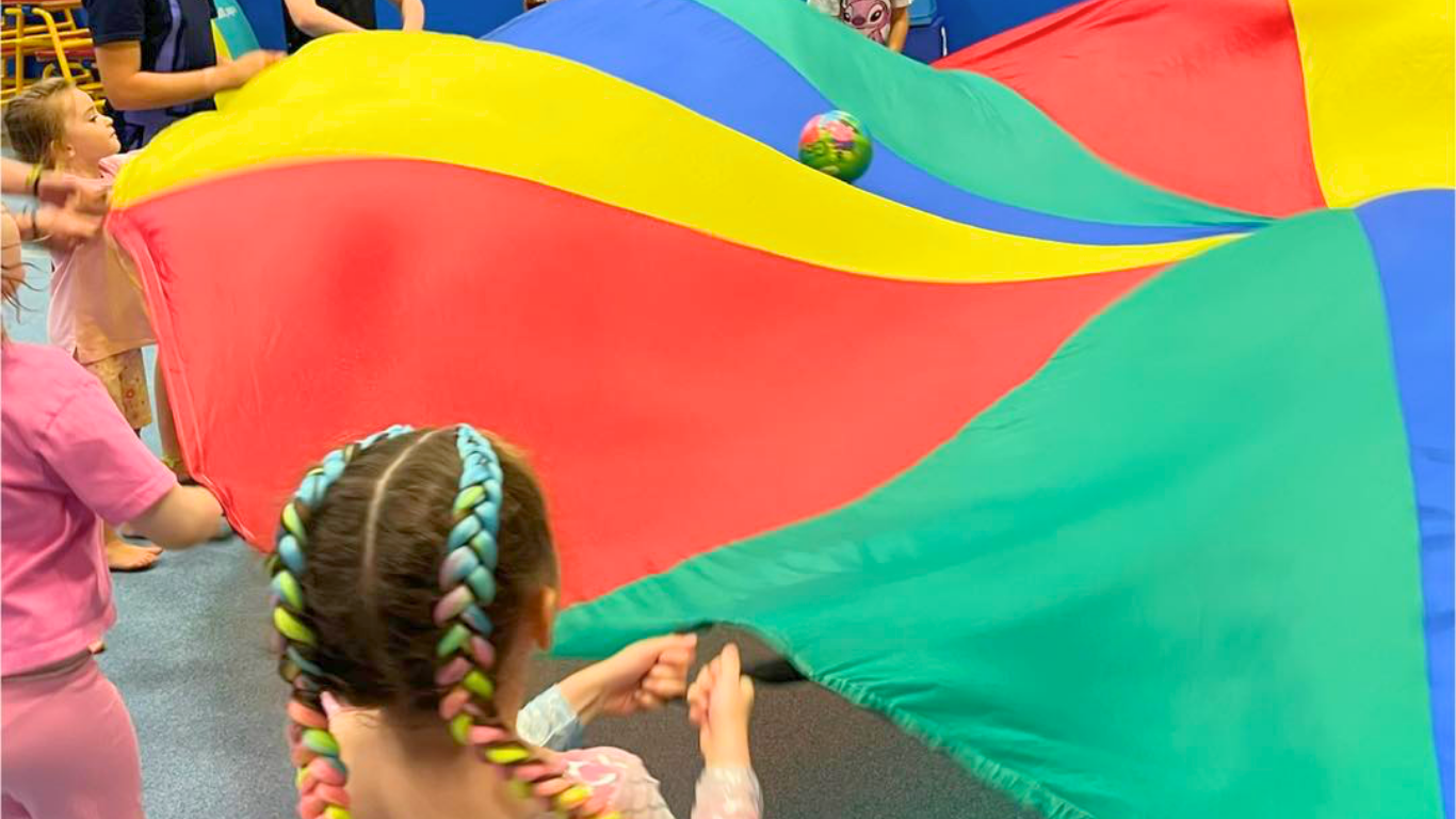 children playing with a parachute at north east gymnastics academy party