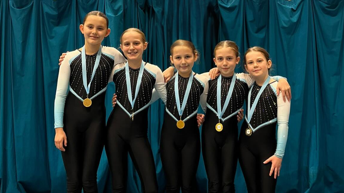 a team of 5 teamgym gymnasts with medals after a competition